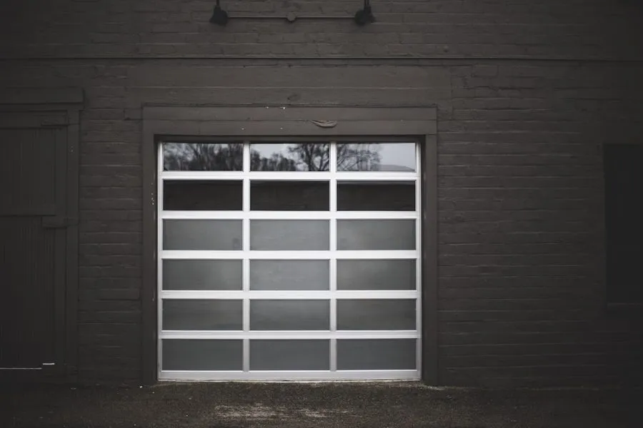 A full view garage door with an aluminium frame and frosted glass panels