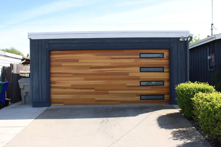 A custom cedar plank garage door with narrow inset windows